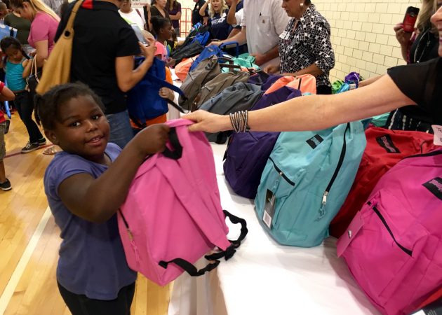 A student receives her backpack during EON's 2016 Backpack Drive.